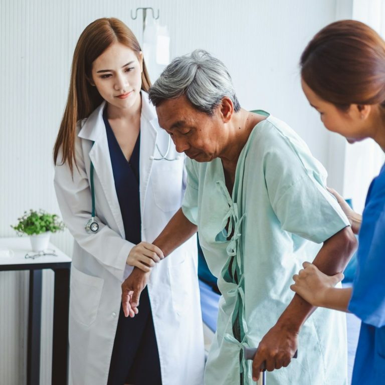 Un fisioterapeuta ayudando a caminar a un paciente en un pasillo amplio o tratando a alguien en un sofá cómodo. Transmite "ayuda profesional