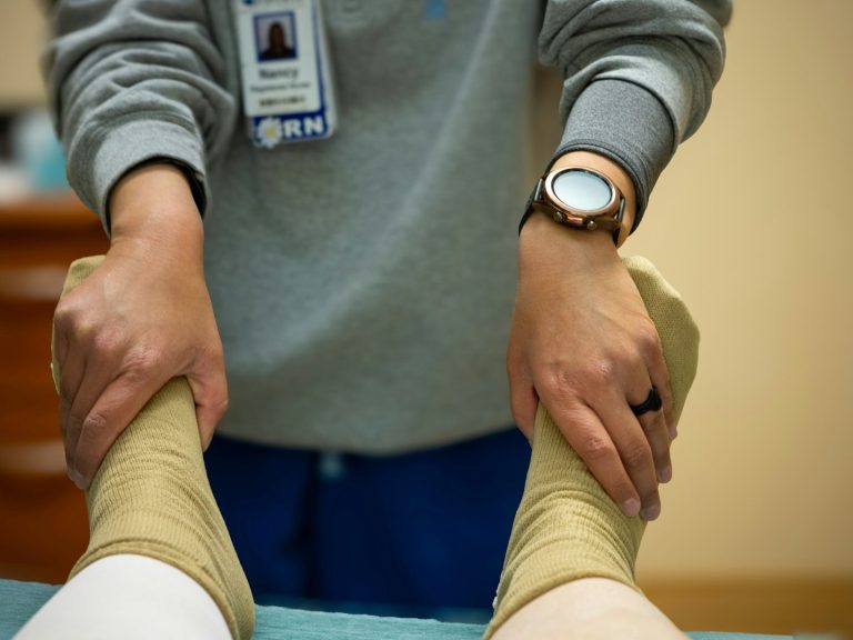 Terapia de rehabilitación a domicilio Madrid en la que se masajean los tobillos de un paciente.