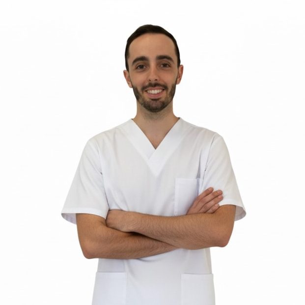 Fisioterapeuta  sonriente con uniforme médico, brazos cruzados, fondo blanco.
