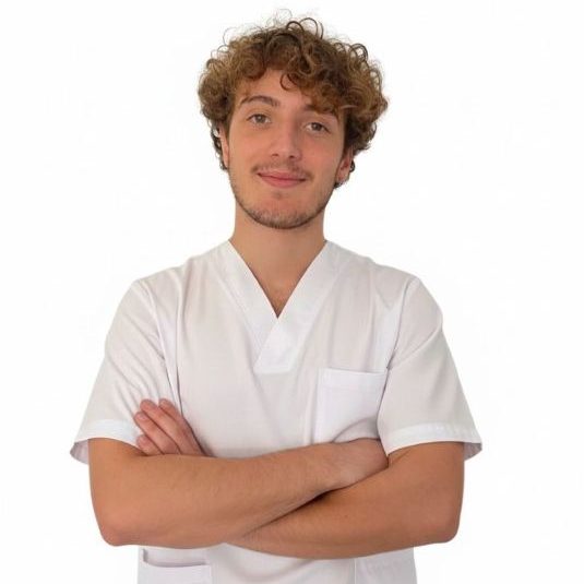 Fisioterapeuta con brazos cruzados y sonrisa.